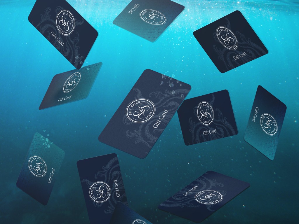 Multiple Salt Water Social gift cards floating underwater with light blue water and air bubbles in the background.